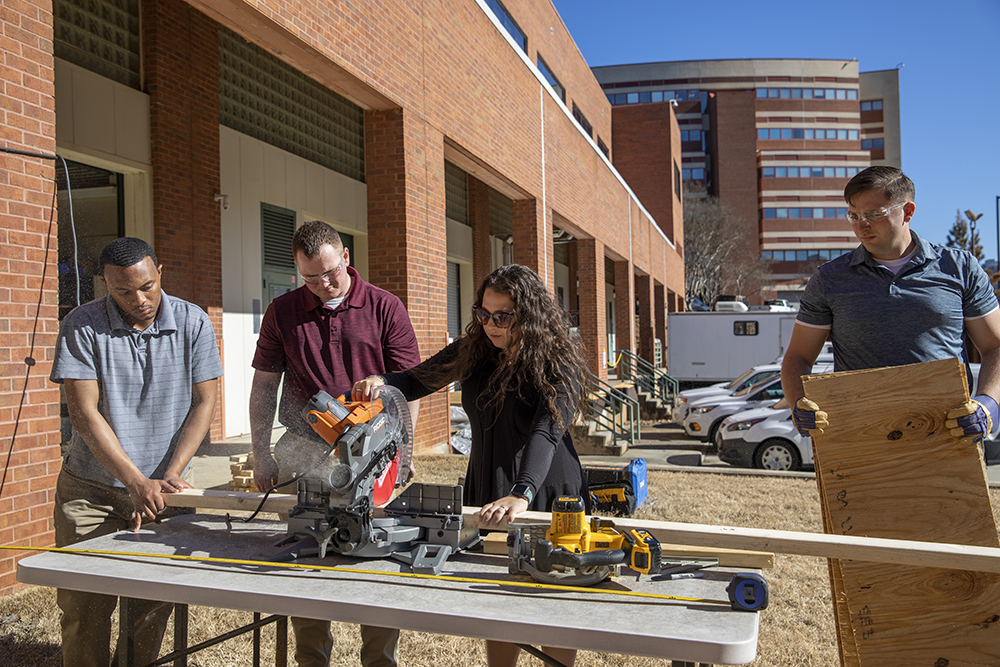 Participant Danielle Shutt uses a saw to help her team build a decoy (Credit: Sean McNeil)