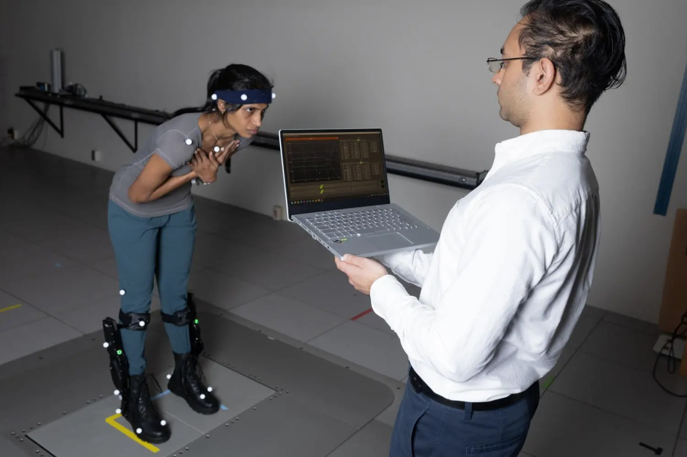 Postdoctoral fellow Surabhi Simha demonstrates how researchers tested whether robotic ankle exoskeleton boots can help people with their balance when its disrupted. 