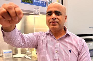 Ankur Singh holds a chip that contains cells used in his research. Singh and fellow researcher Andrés García are working to develop human antibody therapies for hard-to-treat diseases.