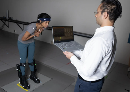 Postdoctoral fellow Surabhi Simha demonstrates how researchers tested whether robotic ankle exoskeleton boots can help people with their balance when its disrupted. 
